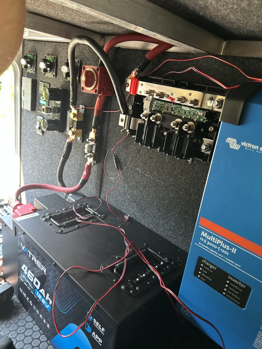 Victron MultiPlus-II inverter and 460Ah lithium battery installed in an RV electrical bay with heavy-gauge cabling.